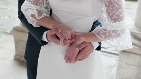 close up of romantic wedding moment with bride and groom holding hands