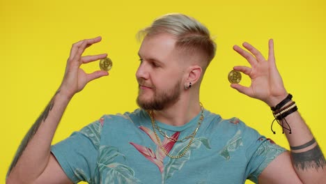 man holding two bitcoin coins