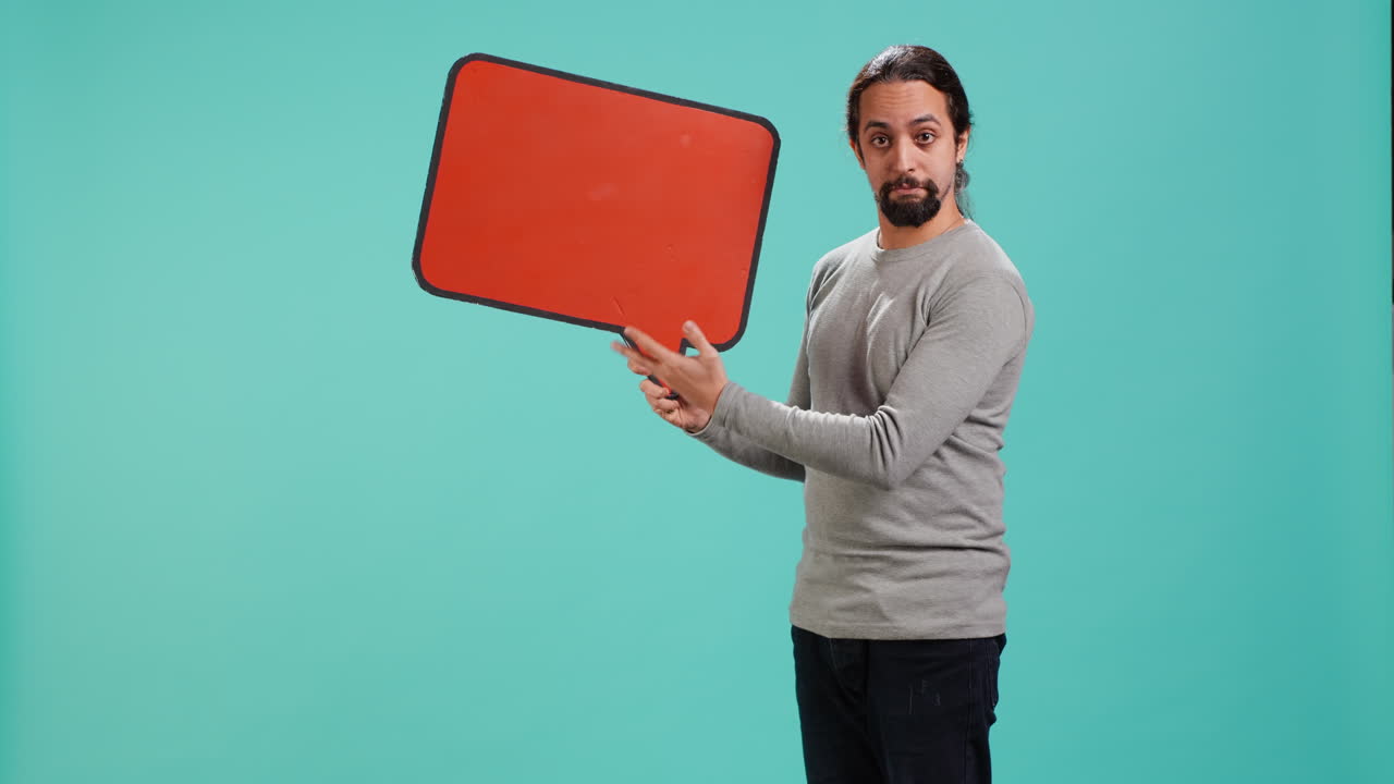 Smiling man presenting red speech bubble sign of empty copy space for message