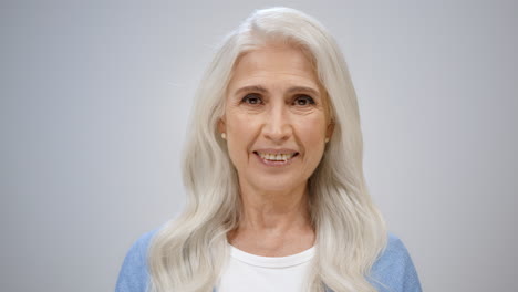 cheerful senior woman looking happy in studio. healthy lady smiling indoors.