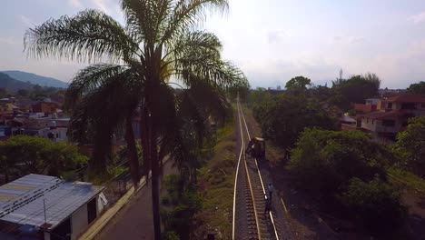 aerial view of train tracks running through a tropical village