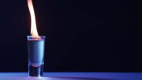 video de alcohol encendido en vidrio con llamas de fuego amarillas y espacio de copia en fondo negro