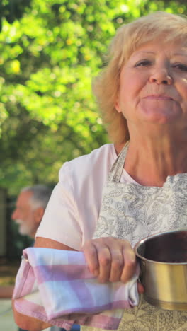 senior woman tasting jam in garden