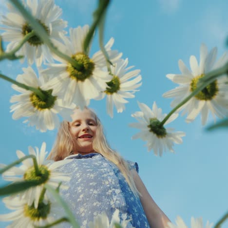 a child plucks daisies in a field