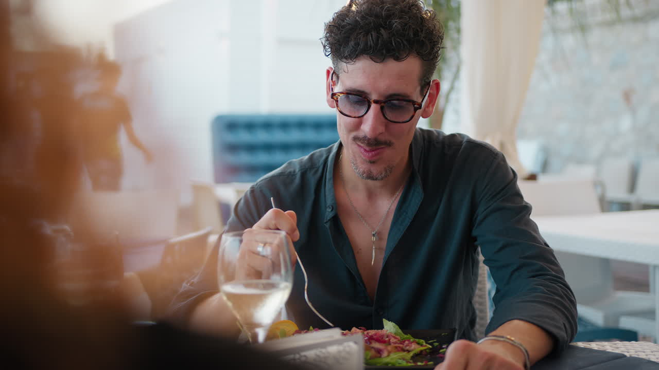 Man Talking And Eating During A Romantic Date At The Beach Restaurant