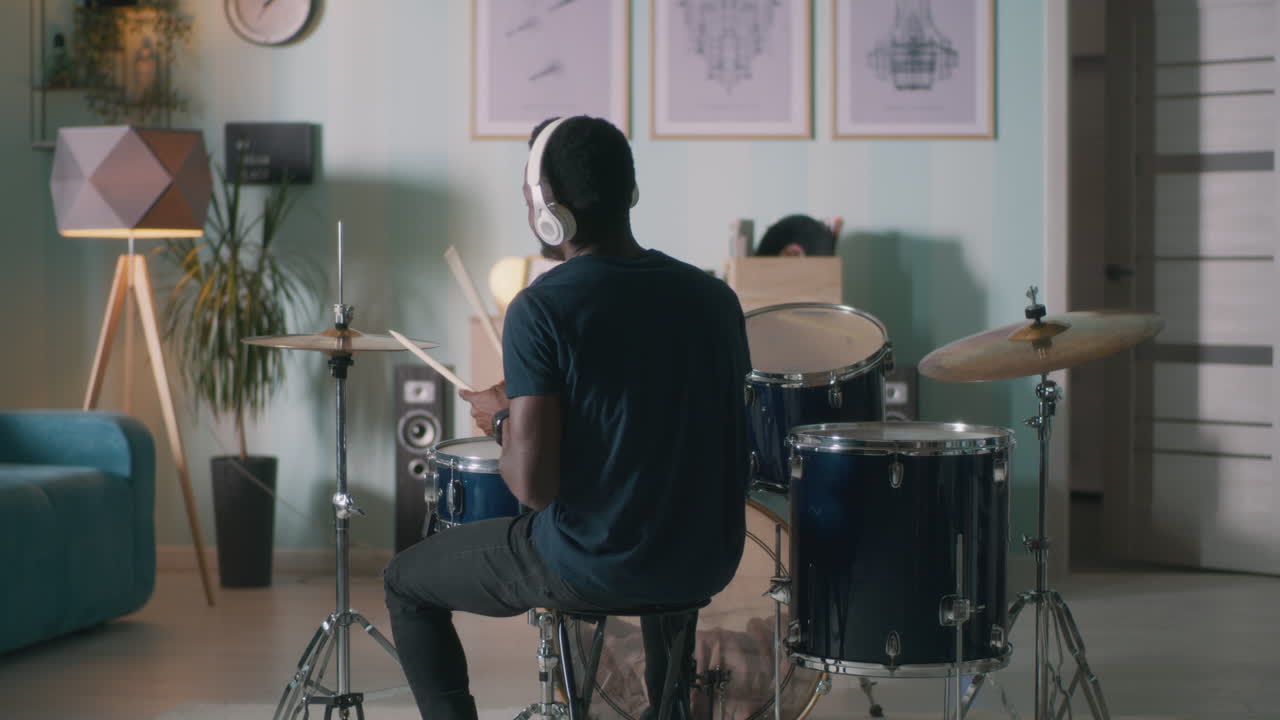 Black Drummer Rehearsing in Studio Black Male Drummer Playing Drum Kit while Rehearsing in Spacious Loft Studio