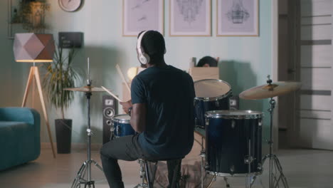 black drummer rehearsing in studio black male drummer playing drum kit while rehearsing in spacious loft studio