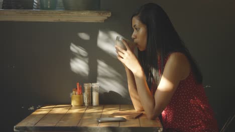vista lateral de una hermosa mujer joven de raza mixta bebiendo café en el café 4k