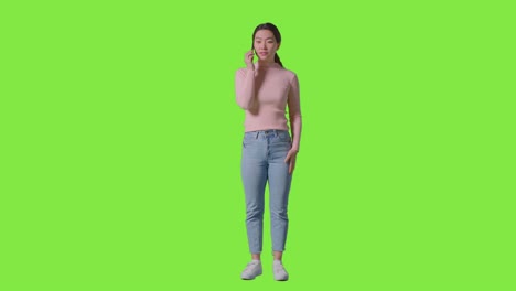 휴대전화에 응답하는 여성과 녹색 화면에 대한 좋은 소식을 얻는 전체 길이의 스튜디오