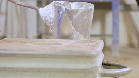 close up of pouring liquid metal into a crucible