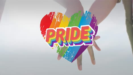 animation of pride text on rainbow heart over diverse couple holding hands