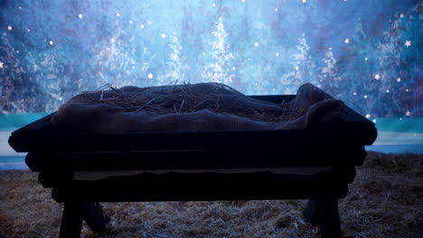 a manger sitting in a hay stable at night time