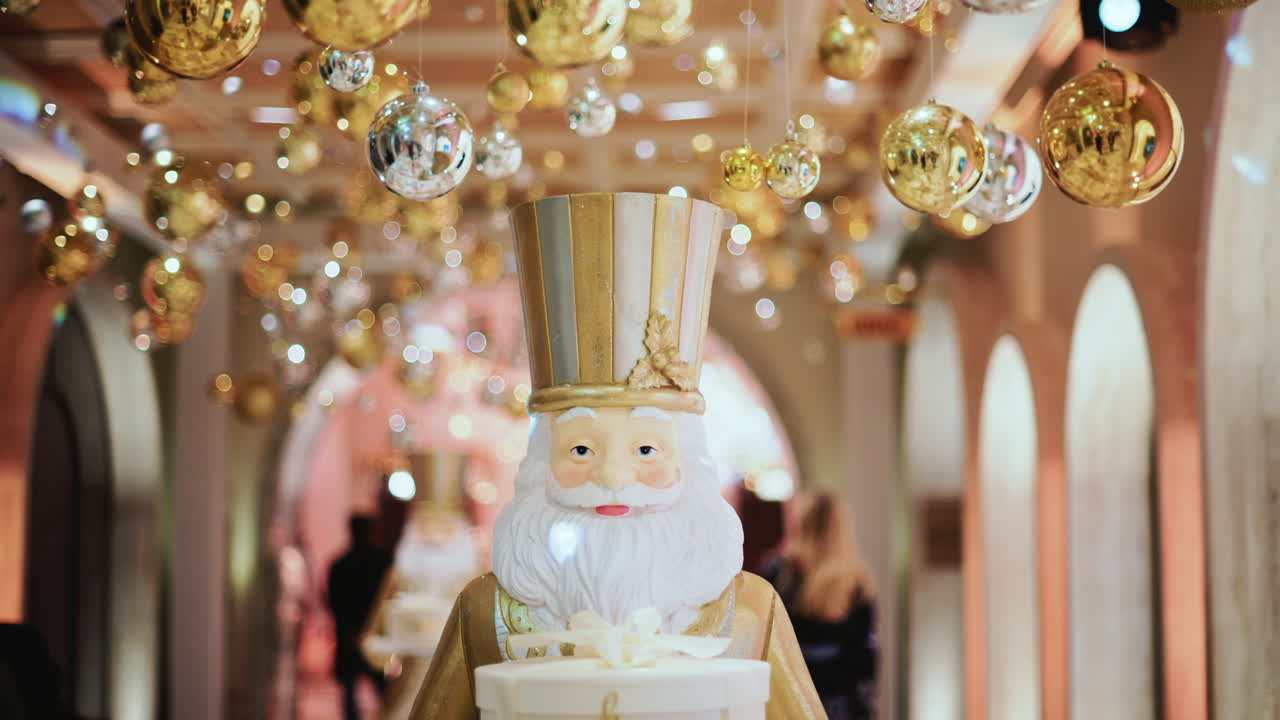 Close up of a Santa Claus figure inside a festive Christmas installation with warm lights and ornaments