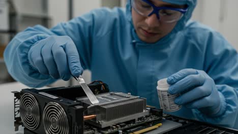 technician applying thermal paste on a computer component in a controlled environment with focused precision and attention to detail