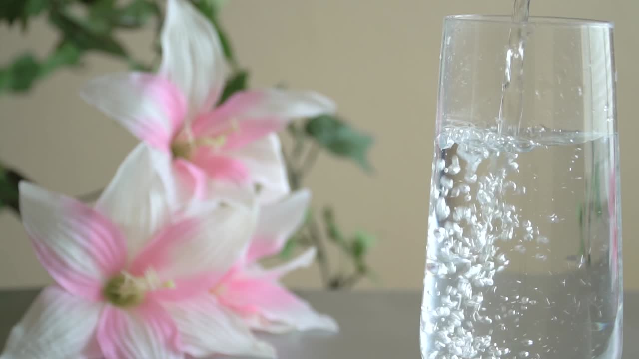 Refreshing water is being poured into a glass to insure health and vibrant lifestyle.