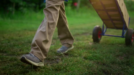 farmer legs going orchard carry agriculture equipment in eco garden plantation.