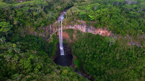 aerial view of a stunning waterfall in a lush tropical forest