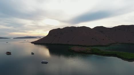 Aerial-view-of-boats-and-mountainous-islands,-in-Komodo-National-Park,-Labuan-Bajo,-Indonesia---tracking,-drone-shot