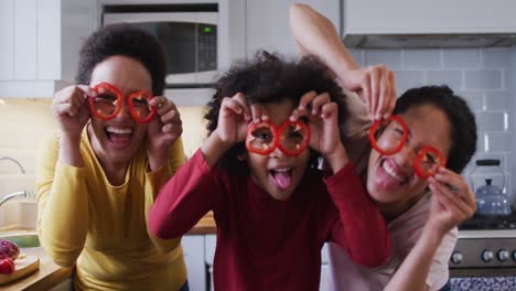 mixed race lesbian couple and daughter preparing food in kitchen