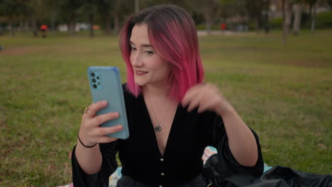 una mujer tomando una selfie en un parque.