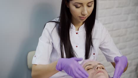 Young woman enjoying of facial massage in spa salon. Beauty Treatment