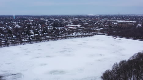 An-aerial-view-from-a-drone,-over-a-square-lake-during-sunrise-on-a-cloudy-morning