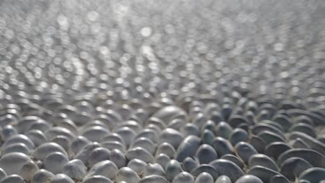 close up details of the traditional greek pebbles stones as tourists walking by in the city center of spetses greek island