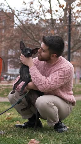 young men enjoying a day outdoors in the park with his dog.