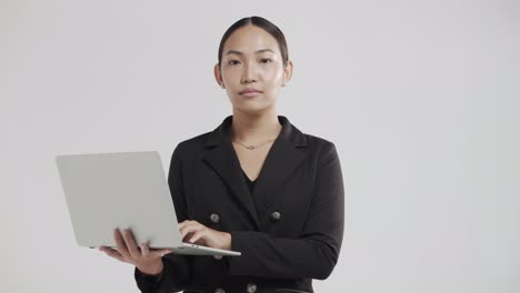 Young-Asian-business-woman-takes-notes-on-her-notebook-during-an-online-video-conference