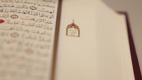 moving shot of an open quran lying on a table, the shot is moving from right to the left side