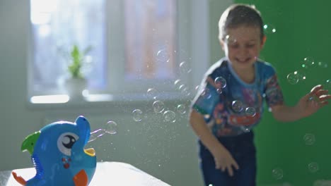 boy play with bubbles. cute male child catches soap bubbles at home