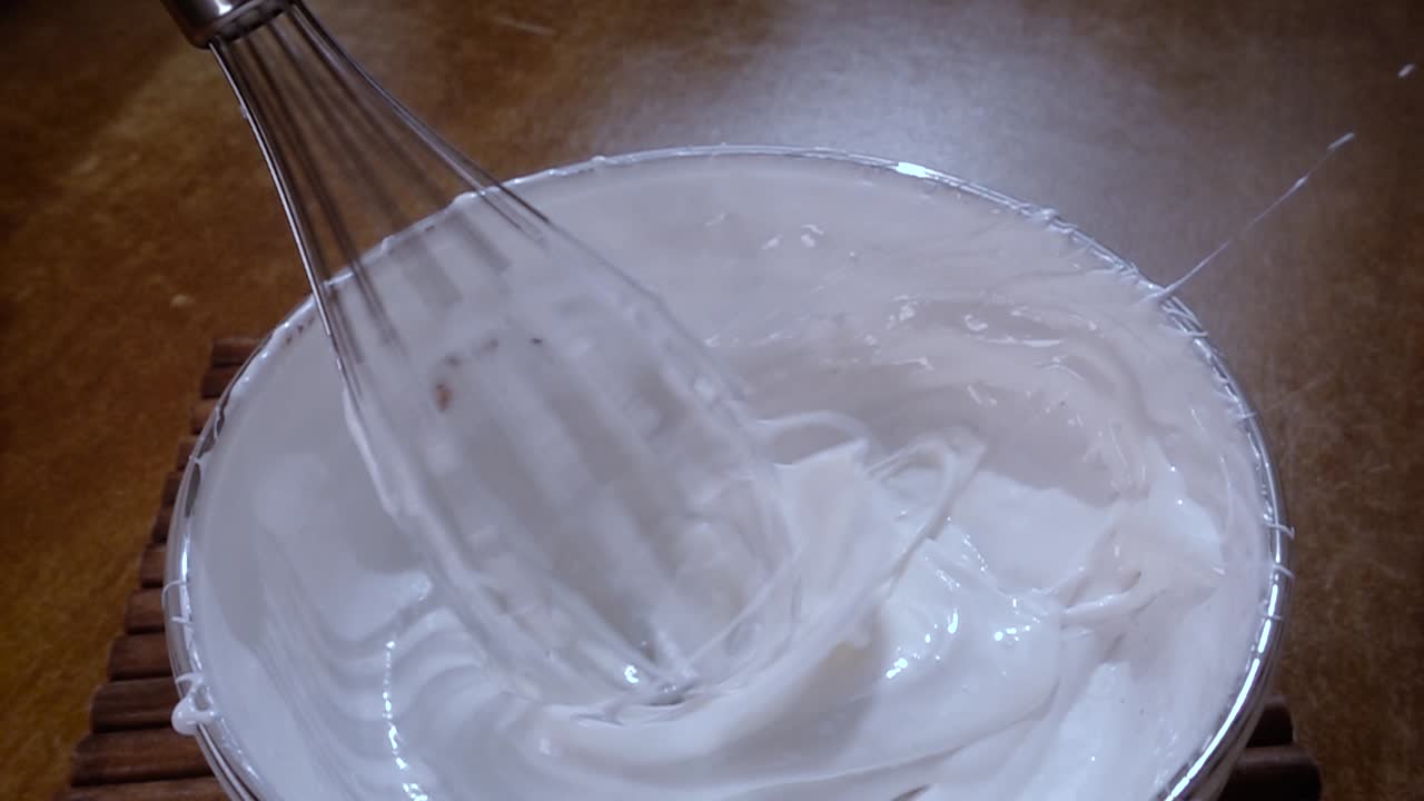 битые яйца с сахаром с помощью миксера. медленная съемка с ротационным отслеживанием.