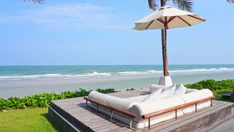 an empty lounge chair faces a desert white sand beach