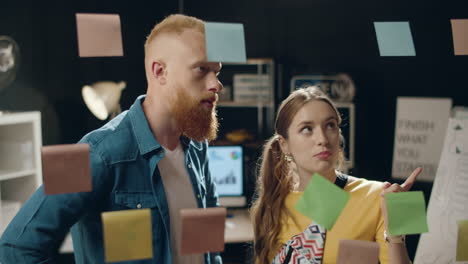 joven mujer de negocios discutiendo ideas con un colega masculino en una oficina hipster