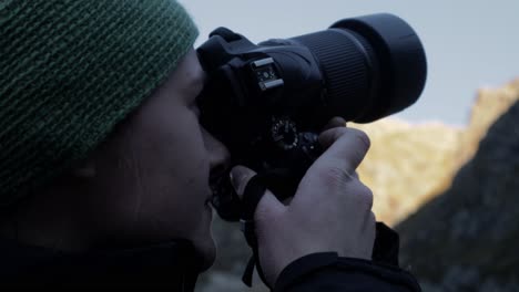 Close-up-shot-of-female-nature-photographer-taking-picture-of-Beautiful-mountain-range-in-Norway