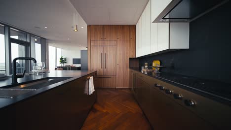 a luxury kitchen with dark accents including dark wood and black granite