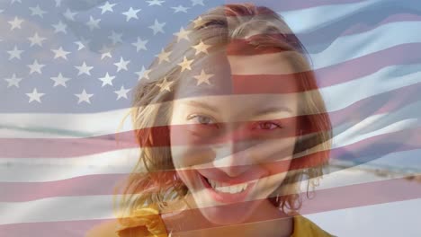 Animation-of-happy-caucasian-woman-by-sea-over-flag-of-usa