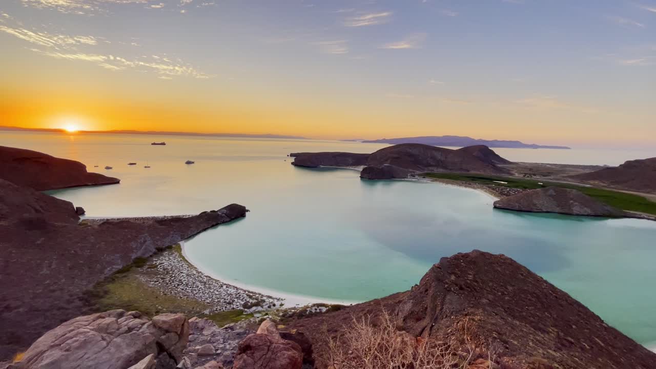 Sunset over a tranquil bay with islands and boats