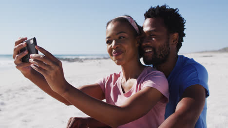 Pareja-Afroamericana-Sonriendo-Tomando-Selfie-Con-Teléfono-Inteligente-En-La-Playa