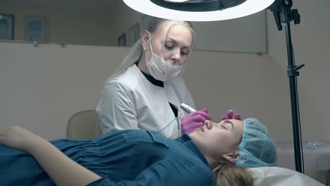 young woman communicates with cosmetician applying make-up