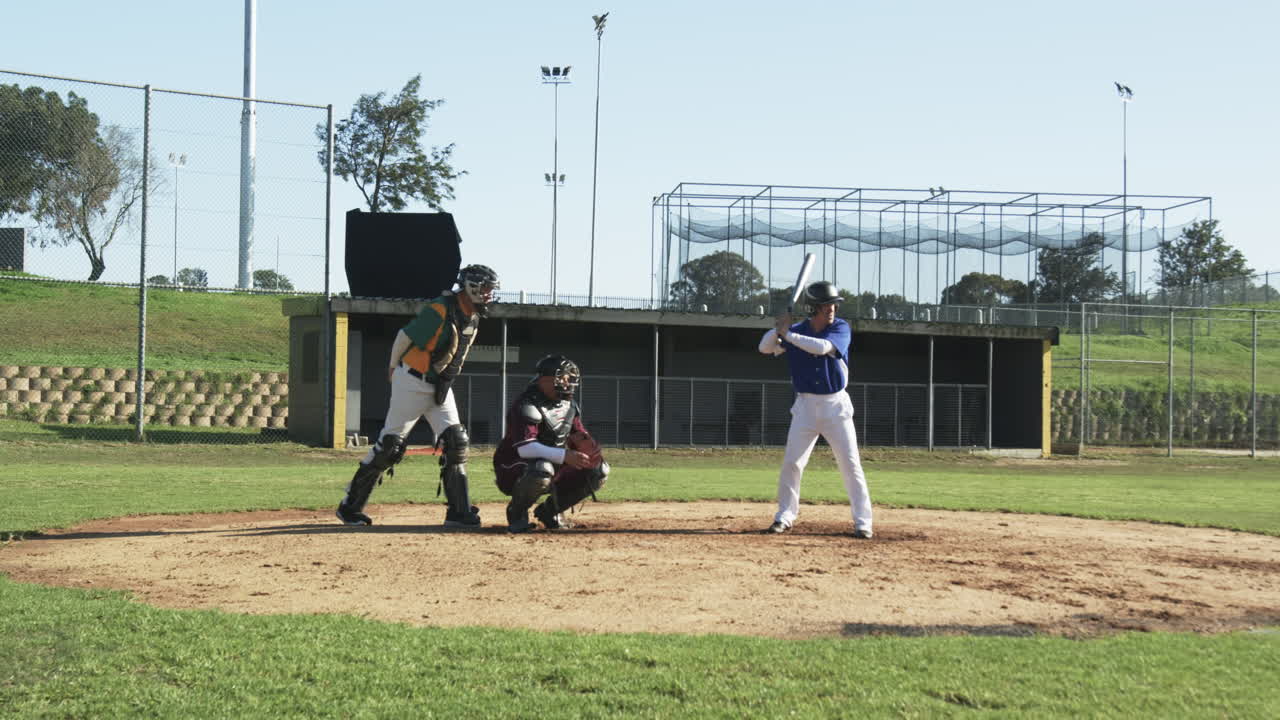 Giocatori di baseball e un arbitro che giocano a baseball, afferrando la palla sul campo, al rallentatore.