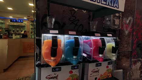 colorful slushie machines in a graffiti-filled alley