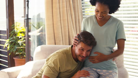 Paar-Mit-Schwangerer-Frau-Im-Schlafzimmer-Zu-Hause-Mit-Mann,-Der-Dem-Herzschlag-Des-Babys-Lauscht