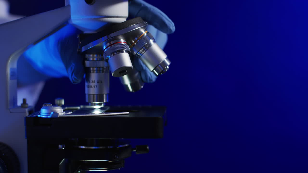 Video of close up of laboratory microscope with copy space on blue background