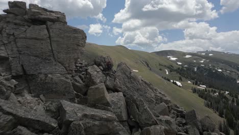 highland plateau flight to young man in tumbled huge summit boulders