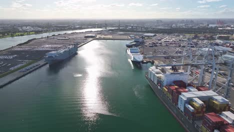 freight terminal with cargo ships cranes and westgate bridge visible in melbourne harbour