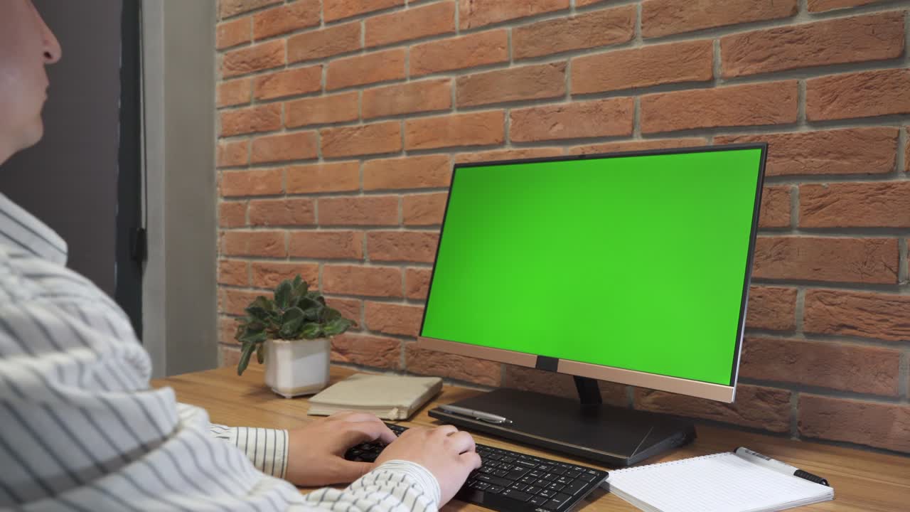 joven trabajando en una computadora con pantalla verde en la oficina. 4k
