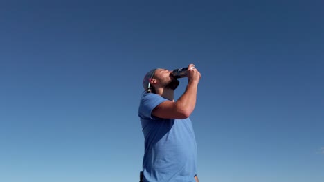 Hiker-drinking-beer-on-peak-at-Rocky-Mountain-range-Reveal-Kananaskis-Alberta-British-Columbia-border-Canada