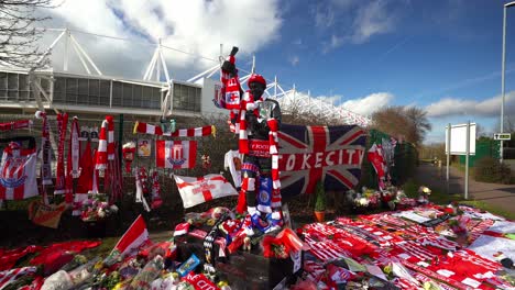 people pay their respects at the gordon banks statue by the stoke city stadium, people signing shirts, scarves, flags and the book of remembrance