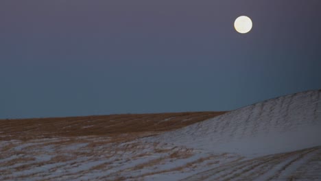 una superluna sobre un campo cubierto de nieve